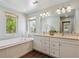 Bright bathroom with a tub, dual sinks, and large windows that provide plenty of natural light at 1109 Jersey St, Denver, CO 80220