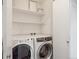 Well-lit laundry room features a full-size washer, dryer, and ample shelving for storage at 1109 Jersey St, Denver, CO 80220