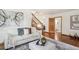 Bright living room showing natural light, a staircase, hardwood floors, and white couch at 1109 Jersey St, Denver, CO 80220
