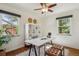 Bright office featuring hardwood floors, a ceiling fan, shelving, two windows, and a white work desk at 1109 Jersey St, Denver, CO 80220
