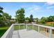 Backyard wooden deck with white railings overlooking a lush green lawn and a charming neighborhood setting at 9196 W Maplewood Ave, Littleton, CO 80123