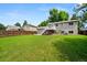 Expansive backyard featuring a deck, mature trees, and a well-maintained lawn at 9196 W Maplewood Ave, Littleton, CO 80123