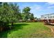 Large, grassy backyard enclosed by a wooden fence with mature trees offering shade at 9196 W Maplewood Ave, Littleton, CO 80123