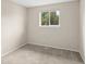 A cozy bedroom showcasing neutral walls and soft carpeting, complemented by a bright window at 9196 W Maplewood Ave, Littleton, CO 80123