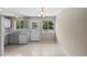 Kitchen featuring white cabinetry, a garden window, and access to backyard deck at 9196 W Maplewood Ave, Littleton, CO 80123