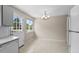 Eat-in kitchen featuring appliances, a chandelier, and a door to backyard deck at 9196 W Maplewood Ave, Littleton, CO 80123