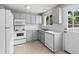 Galley kitchen featuring white appliances, subway tile backsplash, and natural light at 9196 W Maplewood Ave, Littleton, CO 80123