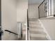 Carpeted staircase with decorative iron railing leads to the upper level at 9196 W Maplewood Ave, Littleton, CO 80123