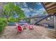 Spacious stone patio with a firepit, an adjacent outdoor dining area and stairs to the upper level at 4701 Homestead St, Bow Mar, CO 80123