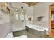 This bathroom features a glass shower and soaking tub with tile surround and floors at 4701 Homestead St, Bow Mar, CO 80123
