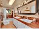 Well-lit bathroom featuring double sinks, a large mirror, and earth-toned tile at 4701 Homestead St, Bow Mar, CO 80123