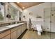 Bright bathroom with double sink vanity, tiled countertops, and window with natural light at 4701 Homestead St, Bow Mar, CO 80123