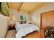 Cozy bedroom with hardwood floors, a plush bed, and natural light from the window at 4701 Homestead St, Bow Mar, CO 80123