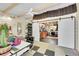 Bright bonus room with white ceiling beams, slider doors and a peek into the workshop/garage at 4701 Homestead St, Bow Mar, CO 80123