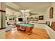Spacious living room with hardwood floors, built-in shelves, and a pool table at 4701 Homestead St, Bow Mar, CO 80123