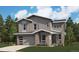 Charming two-story home with gray siding, a brick facade, and an attached two-car garage at 24950 E 42Nd Ave, Aurora, CO 80019