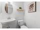 Bathroom with a white vanity, toilet, and a wood-framed mirror at 7068 E Briarwood Dr, Centennial, CO 80112