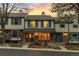 Charming townhome with brick facade and inviting covered porch beneath a beautiful sunset sky at 7068 E Briarwood Dr, Centennial, CO 80112