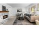 Bright living room featuring a brick fireplace, neutral decor and a large picture window at 7068 E Briarwood Dr, Centennial, CO 80112