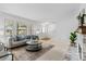 Bright and open living room featuring large window, neutral decor, fireplace, and access to staircase at 7068 E Briarwood Dr, Centennial, CO 80112