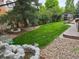Backyard featuring a rock water feature, lush lawn, gravel beds, and a shed at 16458 W Ellsworth Dr, Golden, CO 80401