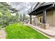Spacious backyard featuring a covered patio, outdoor dining area, firepit, hot tub, and lush landscaping at 16458 W Ellsworth Dr, Golden, CO 80401