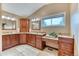 Bathroom with double sinks, granite counters, wood cabinets, and a separate makeup vanity at 16458 W Ellsworth Dr, Golden, CO 80401