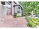 Inviting home entrance featuring a fountain, stone walkway, lush landscaping, and a wooden front door at 16458 W Ellsworth Dr, Golden, CO 80401