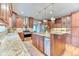 Well-lit kitchen featuring custom cabinets, a granite counter-top island, and stainless steel appliances at 16458 W Ellsworth Dr, Golden, CO 80401