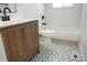 Updated bathroom with stylish vanity, tub, and patterned tile floor at 14544 March Dr, Denver, CO 80239