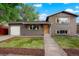 Charming gray brick home with manicured front lawn, garage, and wooden accents at 14544 March Dr, Denver, CO 80239