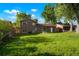 Back exterior view of the home featuring a lush green lawn, and mature shade trees at 14544 March Dr, Denver, CO 80239
