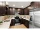 Modern kitchen with stainless steel appliances, dark cabinets, and white countertops at 14544 March Dr, Denver, CO 80239