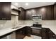 Modern kitchen featuring stainless steel appliances, granite countertops, and ample dark wood cabinetry at 14544 March Dr, Denver, CO 80239