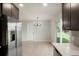 Bright kitchen featuring stainless steel refrigerator and adjacent dining area with exterior access at 14544 March Dr, Denver, CO 80239