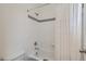 Bright bathroom featuring a shower and tub with white tile and decorative black tile accents at 14881 Rider Pl, Parker, CO 80134