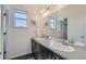 Clean bathroom featuring double sinks, dark cabinetry, and a large mirror for a bright, open feel at 14881 Rider Pl, Parker, CO 80134