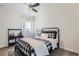 Bright bedroom features a metal bed frame and ceiling fan, with a large window providing natural light at 14881 Rider Pl, Parker, CO 80134