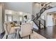 Bright dining area with stairs, hardwood floors, and an adjacent living room creates a welcoming and flowing space at 14881 Rider Pl, Parker, CO 80134