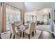 Open dining area with a table set for six, flowing into the living room, featuring hardwood floors and ample natural light at 14881 Rider Pl, Parker, CO 80134