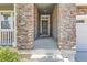 Welcoming front entryway with stone columns, a classic wooden door, and elegant wreath detailing for added charm at 14881 Rider Pl, Parker, CO 80134