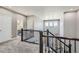 Hallway with dark wood railing leading to the staircase, with a view of rooms and natural light at 14881 Rider Pl, Parker, CO 80134