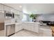 Bright kitchen showcases white cabinetry, stainless steel appliances, and an eat-in breakfast bar at 14881 Rider Pl, Parker, CO 80134