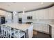 Modern kitchen with white cabinets, stainless steel appliances, a large island with seating, and dark hardwood floors at 14881 Rider Pl, Parker, CO 80134