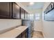 Functional laundry room with ample cabinet space, a utility sink, and a modern washer and dryer at 14881 Rider Pl, Parker, CO 80134