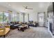 Inviting living room with a ceiling fan, large windows, comfortable sofas, a fireplace, and neutral carpet at 14881 Rider Pl, Parker, CO 80134