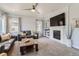 Relaxing living area featuring a fireplace with built-ins, two comfortable sofas, a ceiling fan, and large windows at 14881 Rider Pl, Parker, CO 80134