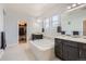 Bright main bathroom with a soaking tub, double vanities, and access to a walk-in closet at 14881 Rider Pl, Parker, CO 80134