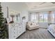 Comfortable main bedroom with a stylish dresser, neutral decor, and a view of the landscaped outdoors at 14881 Rider Pl, Parker, CO 80134