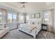 Light-filled main bedroom with a large bed, neutral decor, and a cozy sitting area by the windows at 14881 Rider Pl, Parker, CO 80134